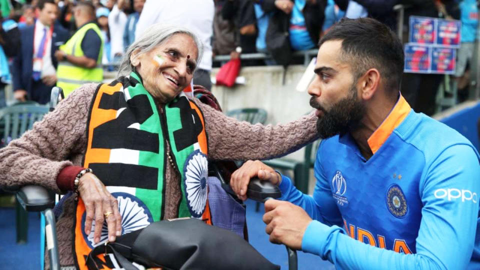 Indian cricket superfan Charulata Patel, pictured with India's captain Virat Kohli, has died, aged 87. Picture: Twitter/@RCBTweets