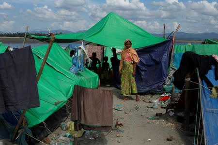 FILE PHOTO: A Rohingya Muslim woman stands as she waits to cross the border to go to Bangladesh, in a temporary camp outside Maungdaw