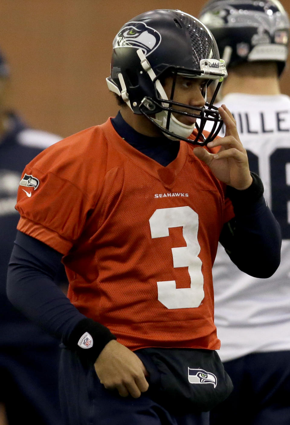 Seattle Seahawks quarterback Russell Wilson adjusts his helmet at the start of NFL football practice Thursday, Jan. 30, 2014, in East Rutherford, N.J. The Seahawks and the Denver Broncos are scheduled to play in the Super Bowl XLVIII football game Sunday, Feb. 2, 2014. (AP Photo)