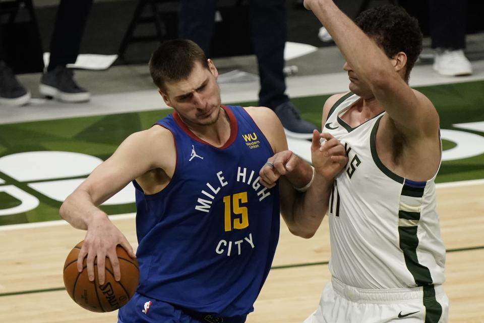 Denver Nuggets' Nikola Jokic tries to get past Milwaukee Bucks' Brook Lopez during the first half of an NBA basketball game Tuesday, March 2, 2021, in Milwaukee. (AP Photo/Morry Gash)