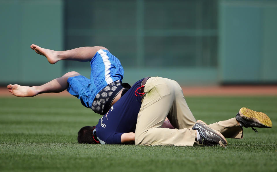 Fenway Park security tackles a fan who ran out onto the field during the ninth inning of the Toronto Blue Jays 13-5 win over the Boston Red Sox in a game at Fenway Park on June 14, 2015 in Boston, Massachusetts. (Photo by Winslow Townson/Getty Images)
