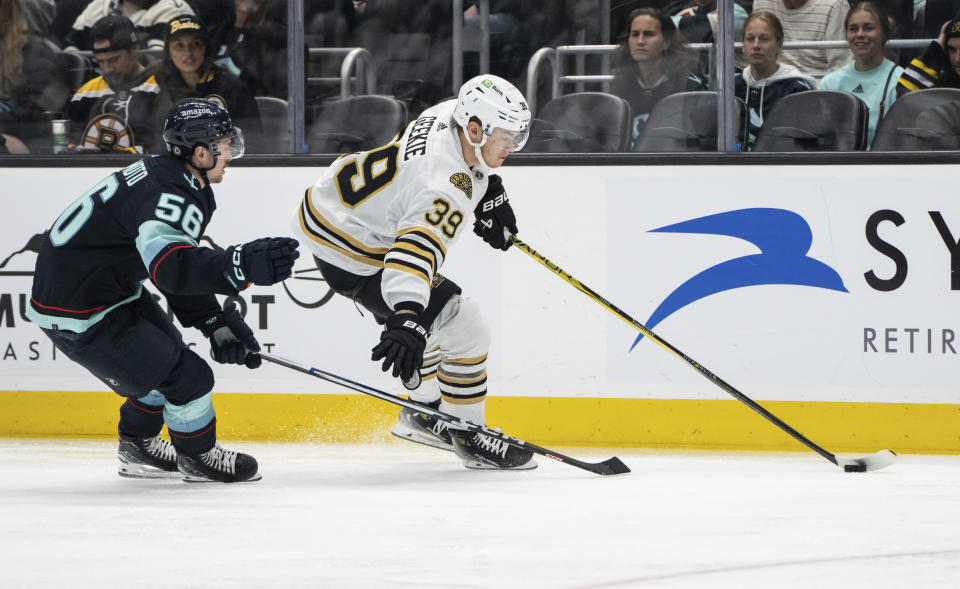 Boston Bruins forward Morgan Geekie, right, skates against Seattle Kraken forward Kailer Yamamoto, left, during the first period of an NHL hockey game, Monday, Feb. 26, 2024, in Seattle. (AP Photo/Stephen Brashear)