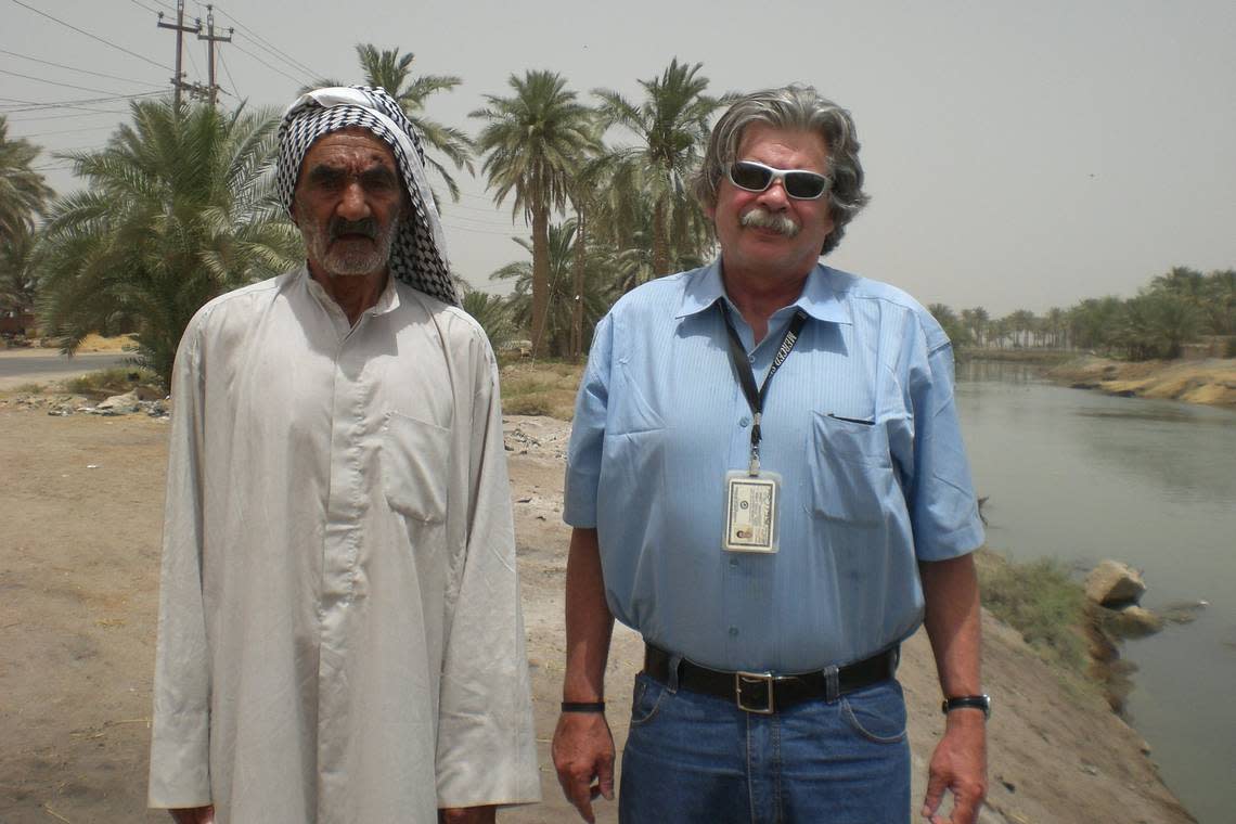 Sun-Star Executive Editor Mike Tharp and Naji Habeeb, 85, an Iraqi rice farmer, stand next to a channel of the Euphrates River near his paddies in southern Iraq.