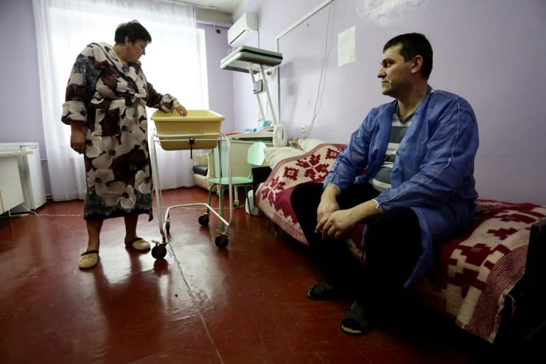 Ukranian woman Olena Gorbatova (L), plays with her baby as her husband Sergiy (R) looks on at the maternity hospital in the war-torn eastern city of Avdiivka