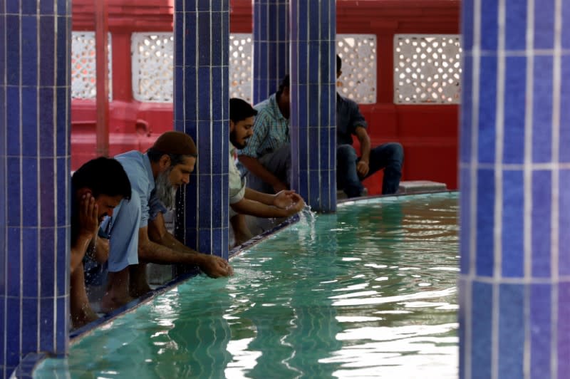 Muslims perform ablution as they gather to attend Friday prayer amid an outbreak of the coronavirus disease (COVID-19), at a mosque in Karachi