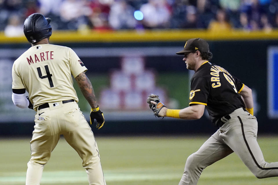 San Diego Padres second baseman Jake Cronenworth, right, tags out Arizona Diamondbacks' Ketel Marte (4) in a run down during the seventh inning of a baseball game in Phoenix, Sunday, Sept. 18, 2022. (AP Photo/Ross D. Franklin)