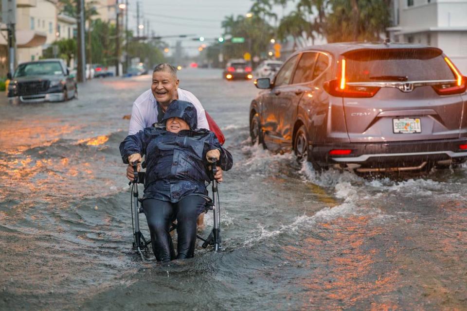 Víctor Corone, de 66 años, empujando a su esposa María Díaz, de 64, en una silla de ruedas a través de más de un pie de agua por la inundación en 84 Street, en Miami Beach, el miércoles 12 de junio de 2024. Díaz tenía una cita con el médico y tuvieron que dejar el auto en el estacionamiento de Collins Ave y caminar más de 20 minutos para llegar a casa.