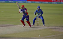 Karachi Kings' Joe Clarke, center, plays a shot while Multan Sultans' Mohammad Rizwan watches during a Pakistan Super League T20 cricket match between Karachi Kings and Multan Sultans at the National Stadium, in Karachi, Pakistan, Saturday, Feb. 27, 2021. (AP Photo/Fareed Khan)