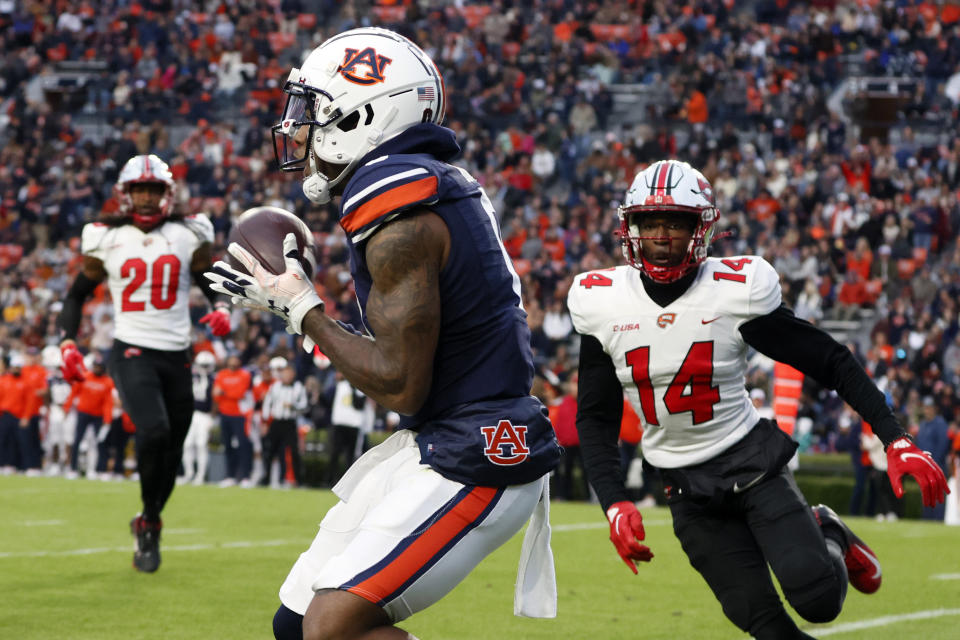 Auburn wide receiver Koy Moore, left, catches a pass for a touchdown as Western Kentucky defensive back Davion Williams (14) defends during the first half of an NCAA college football game Saturday, Nov. 19, 2022, in Auburn, Ala. (AP Photo/Butch Dill)