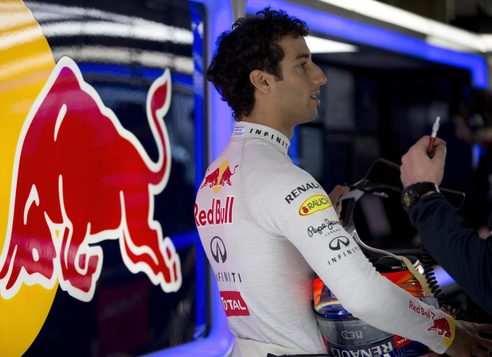 Red Bull driver Daniel Ricciardo of Australia chats with his crew member at the garage during the practice session ahead of Sunday's Chinese Formula One Grand Prix at Shanghai International Circuit in Shanghai, China Friday, April 18, 2014. (AP Photo/Andy Wong)