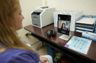 Therapist Norma Kawatta, seen on screen, talks to Paris Carroll, VP of mental health clinical services for Hazel Health, as the pair demonstrate how the company's telehealth therapy service works for Miami-Dade County public school students, on World Mental Health Day, Tuesday, Oct. 10, 2023, at Miami Arts Studio, a public 6th-12th grade magnet school, in Miami. (AP Photo/Rebecca Blackwell)