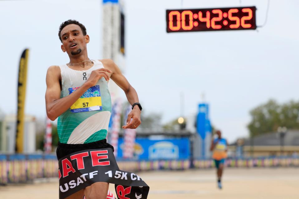 Teshome Asfaha Mekonen (57) breaks the finish line tape ahead of Hillary Bor during the annual Gate River Run Saturday, March 2, 2024 outside EverBank Stadium in Jacksonville, Fla. Mekonen won for the men in 42:51 and Rachel Smith for the women in 48:26.