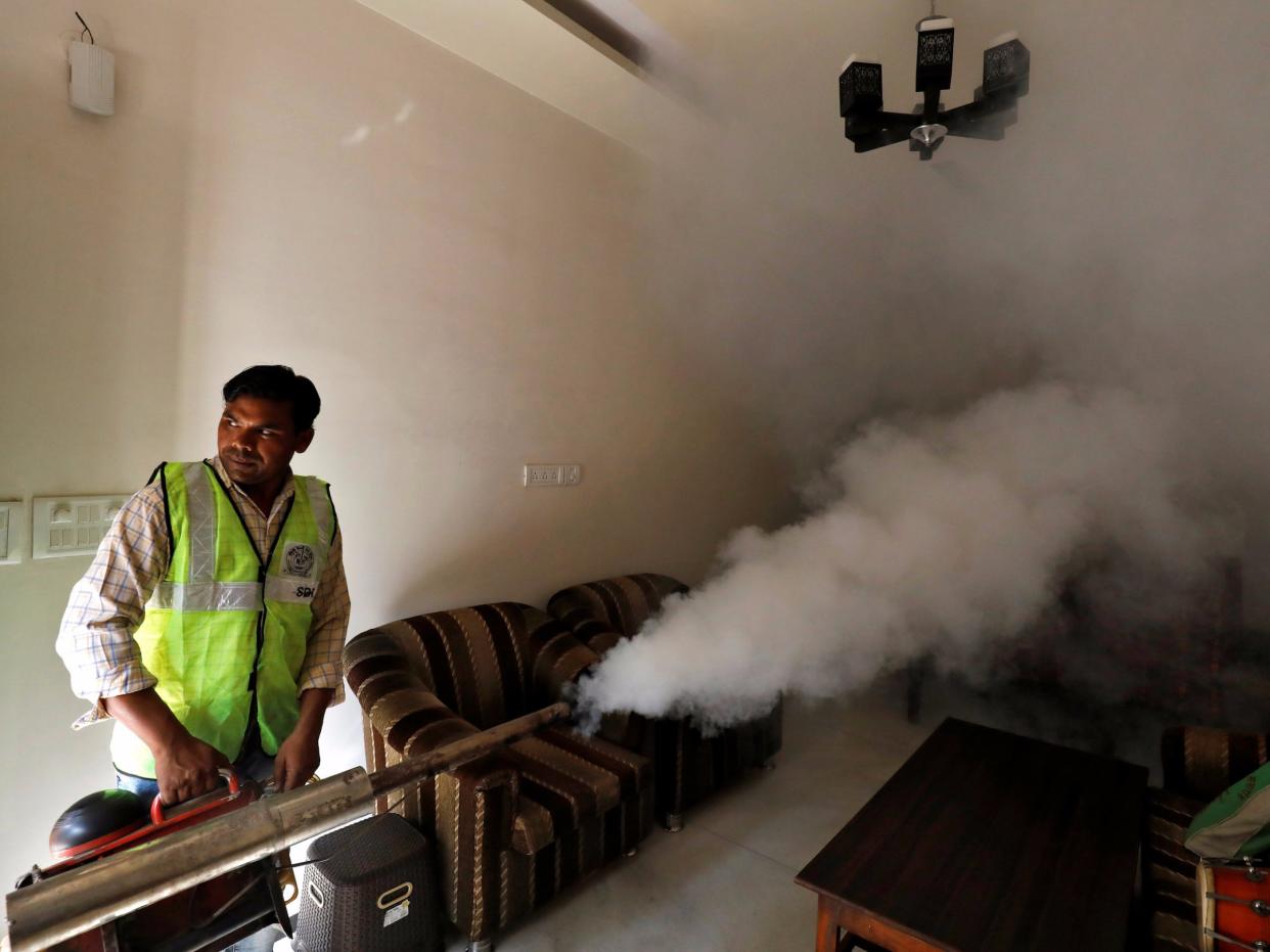 A public health department worker fumigates inside a house to prevent the spread of mosquito borne diseases in New Delhi, India, October 9, 2018.