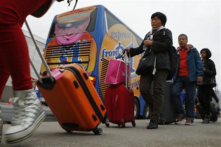 Passengers line up to board a Megabus bus in New York City May 8, 2014. REUTERS/Eduardo Munoz