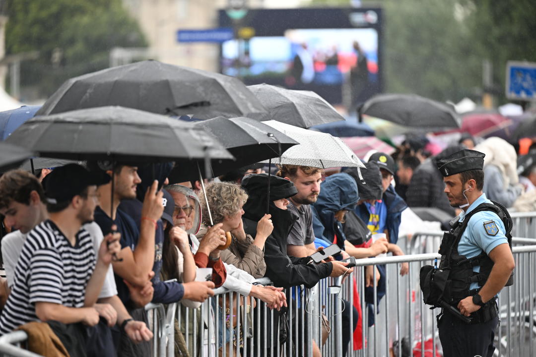 26 July 2024, France, Paris: Olympia, Paris 2024, opening ceremony of the Summer Olympics, onlookers stand under umbrellas in front of a barrier to watch the opening ceremony. Photo: Marijan Murat/dpa (Photo by Marijan Murat/picture alliance via Getty Images)