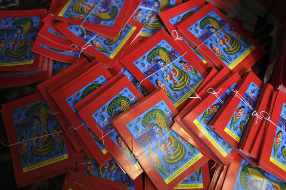 This July 29, 2019, photo shows machine printed posters prepared ahead of the Naag panchami festival at a store in Kathmandu, Nepal. The art and tradition of Nepal’s Chitrakar families, who depicted gods and goddesses on temples, masks of Hindu deities and posters for various religious celebrations is dying because of mass machine printed posters and card-size pictures of gods that are cheaper and more popular. (AP Photo/Niranjan Shrestha)