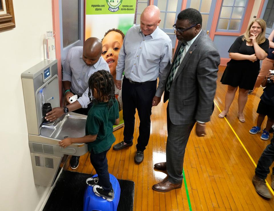 Milwaukee Mayor Cavalier Johnson helps K5 student Noah Bynum get a drink from a new water fountain Monday at Brock Starms Early Childhood Center on West Garfield Avenue in Milwaukee. Looking on are Todd Adams, Zurn Elkay Water Solutions chairman and CEO, and Milwaukee Public Schools superintendent Keith Posley.