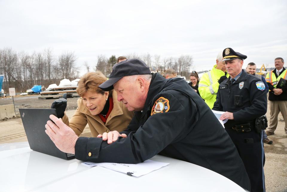 Sen. Jeanne Shaheen, D-New Hampshire, looks at photos of the recent storm damage with Rye Fire Chief Mark Cotreau at the harbor during her first stop of damaged sites Friday, Feb. 2, 2024.