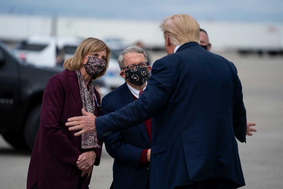 Then-President Donald Trump talks to Ohio Gov. Mike and first lady Fran DeWine after Trump arrived at Rickenbacker International Airport on Oct. 24, 2020, prior to a rally in Circleville.