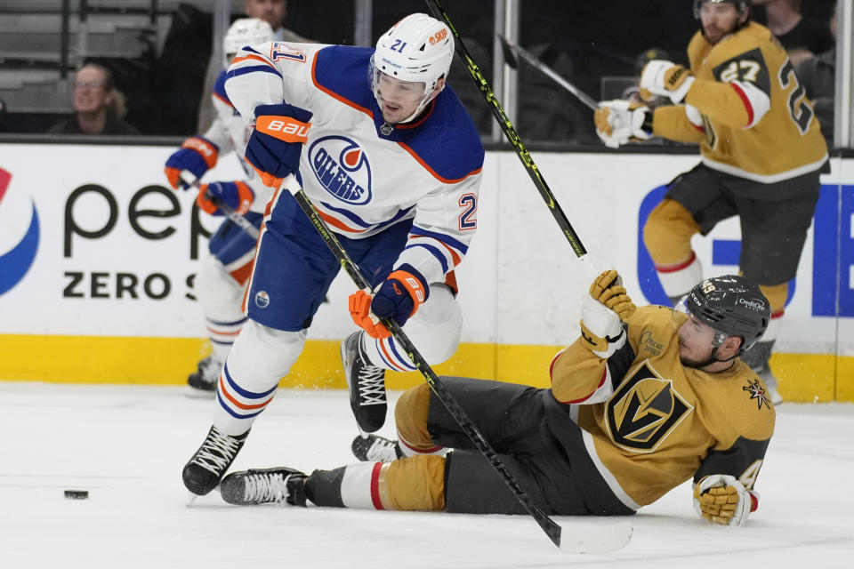 Edmonton Oilers center Klim Kostin (21) and Vegas Golden Knights center Ivan Barbashev (49) vie for the puck during the first period of Game 2 of an NHL hockey Stanley Cup second-round playoff series Saturday, May 6, 2023, in Las Vegas. (AP Photo/John Locher)