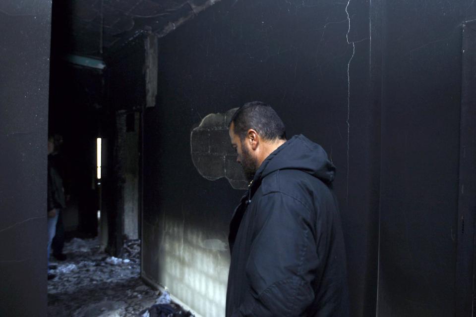 This picture taken on Monday, Feb. 24, 2014, Hisham al-Mughayar, 45, the father of the suicide bomber Nidal al-Mughayar, walks in his burned house which was torched as well as the family’s grocery shop and four vehicles by angry residents after the news spread in the village that Nidal was one of the two suicide attackers who carried out an attack in Beirut near the Iranian culture center, in the southern village of Bisariyeh, Lebanon. Nidal al-Mughayar renewed his travel document last year and told his family he will be leaving Lebanon to settle in Venezuela where there are more opportunities but it turned out later that the young Palestinian man called his family from Syria and it was only then that they knew he has joined jihadis fighting to overthrow President Bashar Assad’s government. (AP Photo/Mohammed Zaatari)