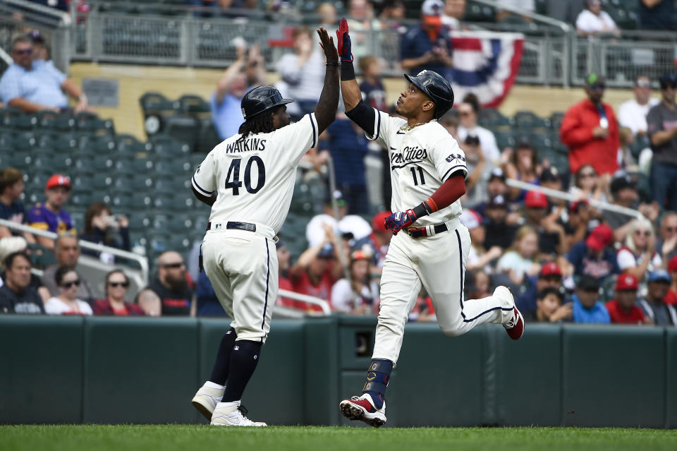 Minnesota Twins' Jorge Polanco (11) celebrates with third base coach Tommy Watkins (40) after hitting a home run against Los Angeles Angels pitcher Andrew Wantz during the third inning of a baseball game Sunday, Sept. 24, 2023, in Minneapolis. (AP Photo/Craig Lassig)