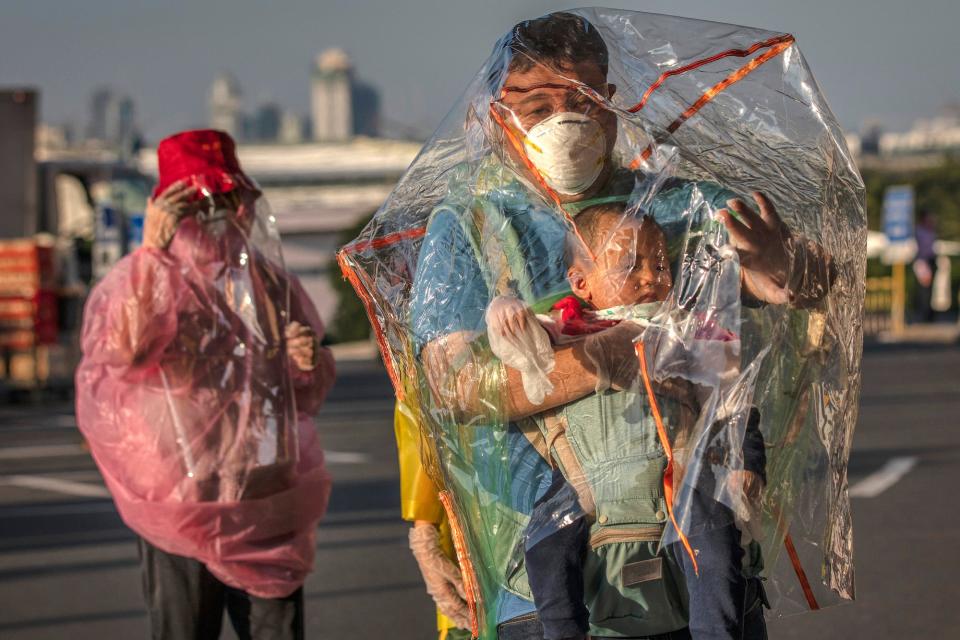 Travelers are seen wearing raincoats, plastic covers, gloves, goggles, and facemasks as they wait for their flight at Ninoy Aquino International Airport on March 18, 2020 in Manila, Philippines.