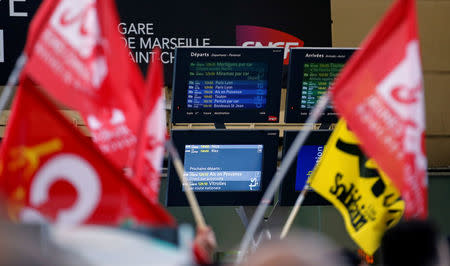 Labour union flags held by railway workers who demonstrate inside the Gare Saint-Charles train station are seen near information screens on the second day of a nationwide strike by French SNCF railway workers, in Marseille, France, April 4, 2018. REUTERS/Jean-Paul Pelissier