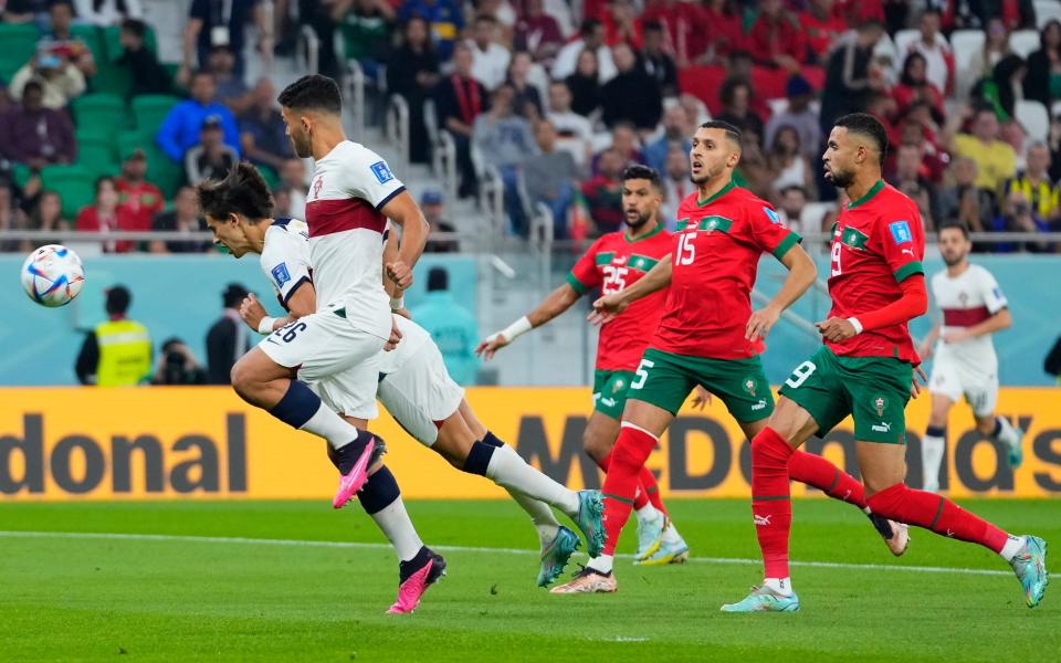 Portugal's Joao Felix, left, attempts a head at goal during the World Cup quarterfinal soccer match between Morocco and Portugal - AP