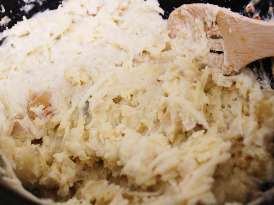 slow cooker mashed potatoes with wooden spoon