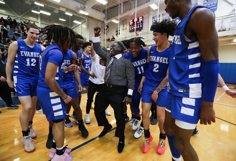 Evangel athletics director Joe Washington, center, celebrates with the team after the Eagles defeated Fairdale, 64-54, during the Sixth Region championship at Valley High School.