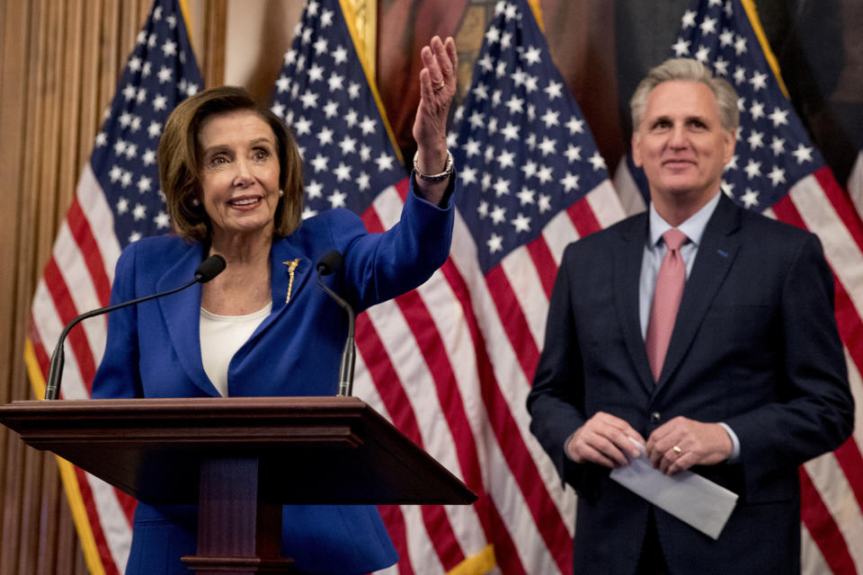 House Speaker Nancy Pelosi of Calif. accompanied by House Minority Leader Kevin McCarthy of Calif., right, speaks before signing the Coronavirus Aid, Relief, and Economic Security (CARES) Act after it passed in the House on Capitol Hill, Friday, March 27, 2020, in Washington. The $2.2 trillion package will head to head to President Donald Trump for his signature. (AP Photo/Andrew Harnik)