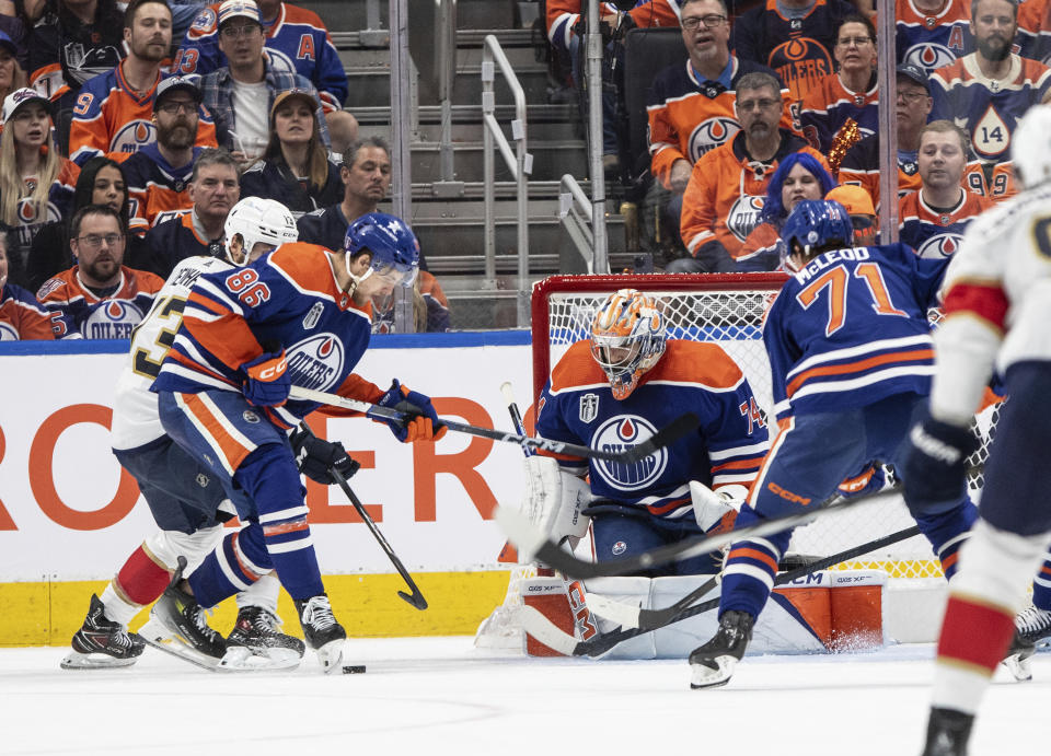 Florida Panthers' Sam Reinhart (13) and Edmonton Oilers' Philip Broberg (86) battle for the rebound from goalie Stuart Skinner (74) during the second period of Game 6 of the NHL hockey Stanley Cup Final, Friday, June 21, 2024, in Edmonton, Alberta. (Jason Franson/The Canadian Press via AP)