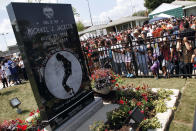 FILE - In this June 25, 2010 file photo, Michael Jackson fans gather around a monument that was unveiled in Gary, Ind., on the first anniversary of the pop icon's death. As the 10th anniversary of Jackson’s death approaches, experts say his music legacy is still going strong despite the documentary’s detailed abuse allegations. (AP Photo/John Smierciak, File)