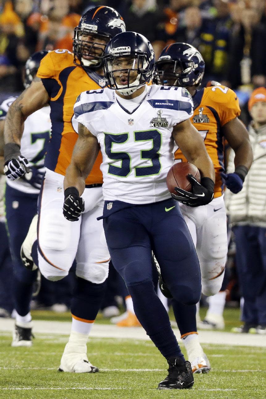 Seattle Seahawks' Malcolm Smith runs for a touchdown after intercepting a Denver Broncos pass during the first half of the NFL Super Bowl XLVIII football game Sunday, Feb. 2, 2014, in East Rutherford, N.J. (AP Photo/Mark Humphrey)