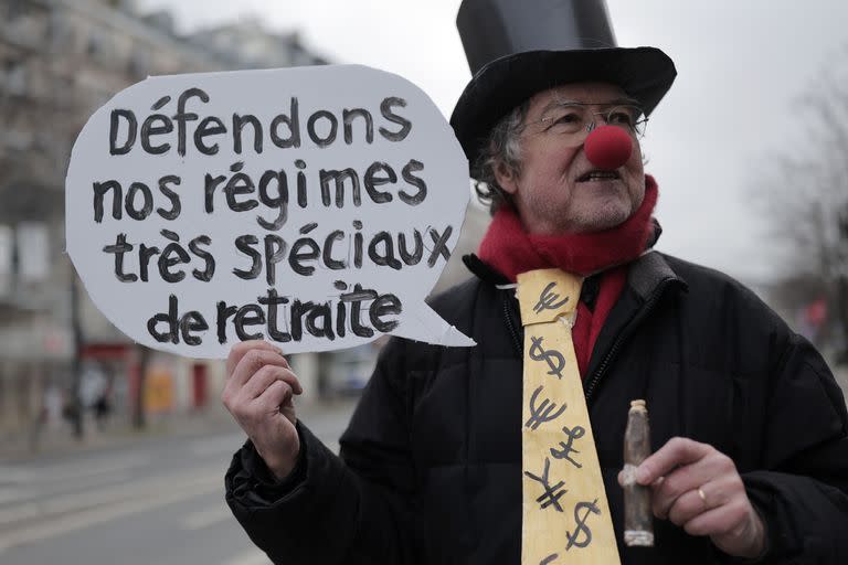 Un manifestante disfrazado que sostiene un cartel que dice "Defendamos nuestros regímenes de pensiones muy especiales" posa ante una manifestación, el jueves 19 de enero de 2023 en París