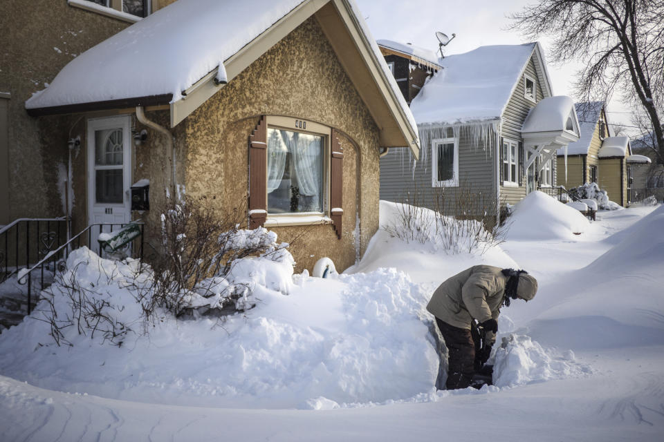 Tom Sundry shovels the sidewalk in front of his house Sunday, Feb. 24, 2019, in Rochester, Minn., after heavy snow overnight.( Joe Ahlquist/The Rochester Post-Bulletin via AP)