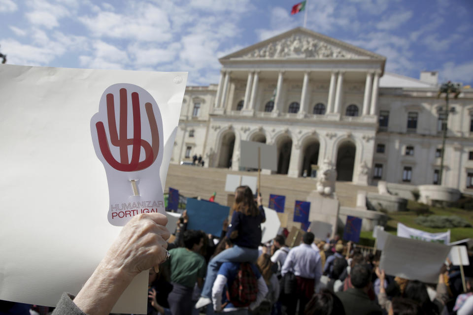 Demonstrators protest outside the Portuguese parliament in Lisbon, Thursday, Feb. 20, 2020. Protesters gathered Thursday outside Portugal's where lawmakers were due to debate proposals that would allow euthanasia and doctor-assisted suicide. Groups which oppose the procedures waved banners and chanted "Sim a vida!" ("Yes to life!") in bright sunshine outside the parliament building in Lisbon. One banner said, "Euthanasia doesn't end suffering, it ends life." (AP Photo/Armando Franca)