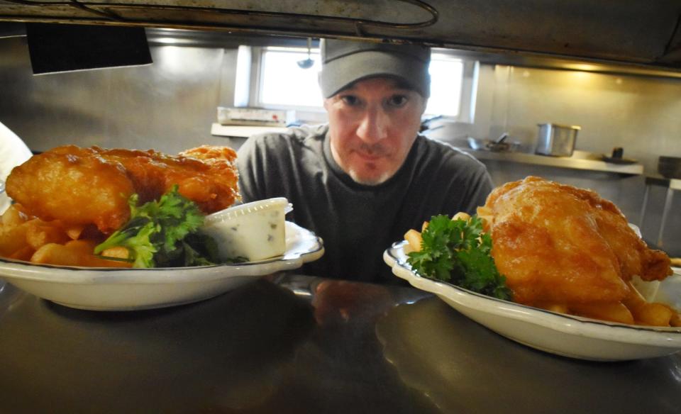 Line cook Dan Francis serves up fish and chips at the Liberal Club in Fall River.