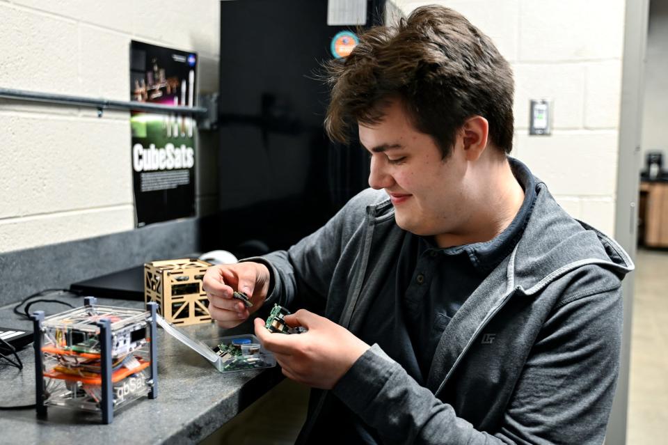 Senior Jack Hammerberg picks through a satellite kit during robotics class on Tuesday, Feb. 7, 2023, at Stockbridge High School. When the pieces are assembled, the satellite will travel to near outer space when it's launched from an East Coast launch site this year.