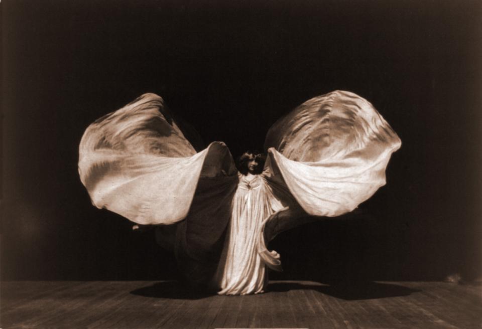 Dancer Loïe Fuller, (1862-1928), in 1902. Raising her very long gown in shape of butterfly. She used her over-sized costumes to extend her dance effects.