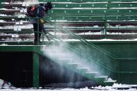 A man uses a snow blower at the stands during the Saskatchewan Roughriders' team practice in Regina, Saskatchewan, November 22, 2013. The Saskatchewan Roughriders will play against the Hamilton Tiger-Cats in the CFL's 101st Grey Cup in Regina. REUTERS/Mark Blinch (CANADA - Tags: SPORT FOOTBALL)