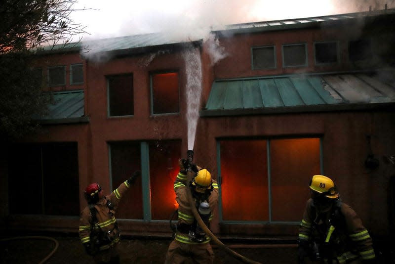 Firefighters try to extinguish a house fire during the Tubbs Fire on October 12, 2017 near Calistoga, California. 