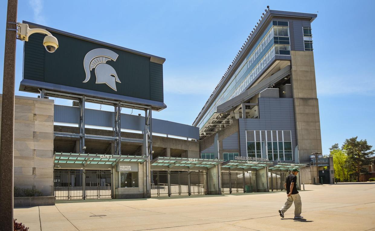 A passerby walks past a camera mounted outside the north entrance of Spartan Stadium, Wednesday, May 10, 2023.