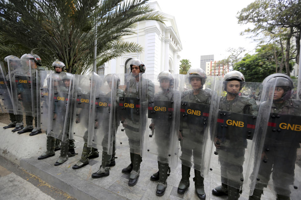 Venezuelan Bolivarian National guards officers form a cordon around the National Assembly building as the opposition-controlled congress met to discuss a move that could provide political cover for greater international involvement in the nation's crisis, in Caracas, Venezuela, Tuesday, May 7, 2019. Military police prevented journalists from entering the National Assembly, and some reporters were harassed by government supporters outside the building. (AP Photo/Fernando Llano)