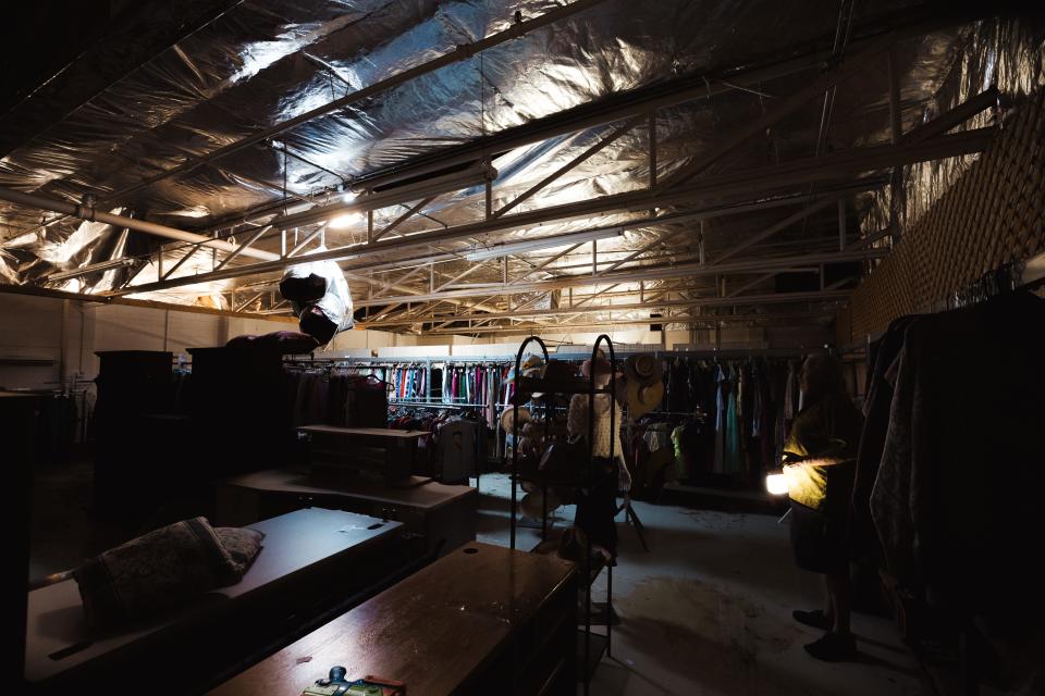 Virgil Reese assesses the damage to his booth of vintage clothes that lies directly under the damaged roof.