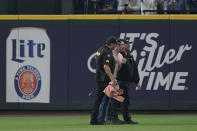 A fan who ran onto the field during the seventh inning is taken away by King County Sheriff's Deputies during a baseball game between the Seattle Mariners and the Oakland Athletics, Sunday, July 3, 2022, in Seattle. (AP Photo/Ted S. Warren)