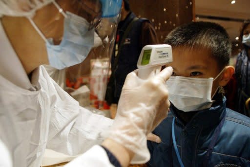 This file photo shows a boy as has his temperature is being taken by a Hong Kong hospital staff. HK confirmed a five-year-old boy had died from scarlet fever on Tuesday, the second death in the southern Chinese city as dozens of new cases were reported