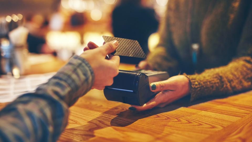 Closeup shot of a customer making a credit card payment in a cafe.