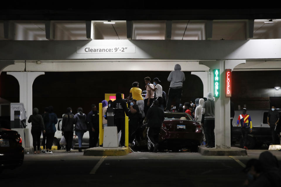 People loot a Wells Fargo ATM, Friday, May 29, 2020, in Minneapolis. Protests continued following the death of George Floyd, who died after being restrained by Minneapolis police officers on Memorial Day. (AP Photo/John Minchillo)